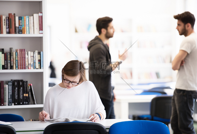 女学生在学校图书馆学习，背景中