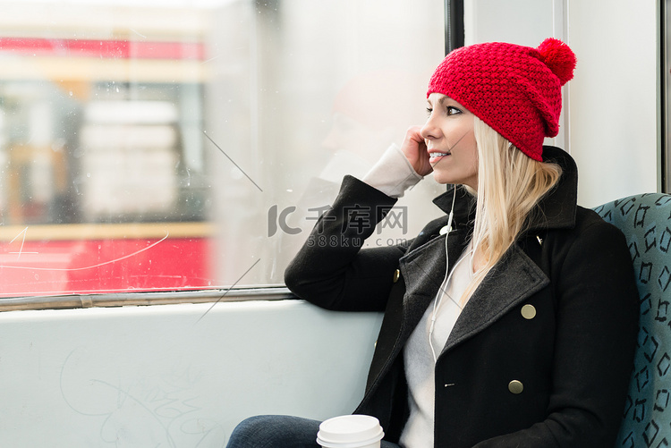 女人用电话望向火车窗外