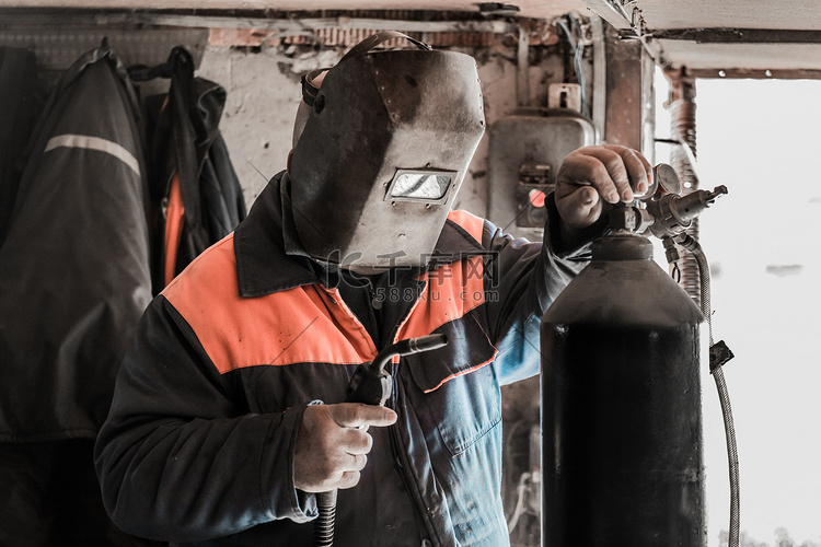 一名男焊工站在焊机和二氧化碳钢