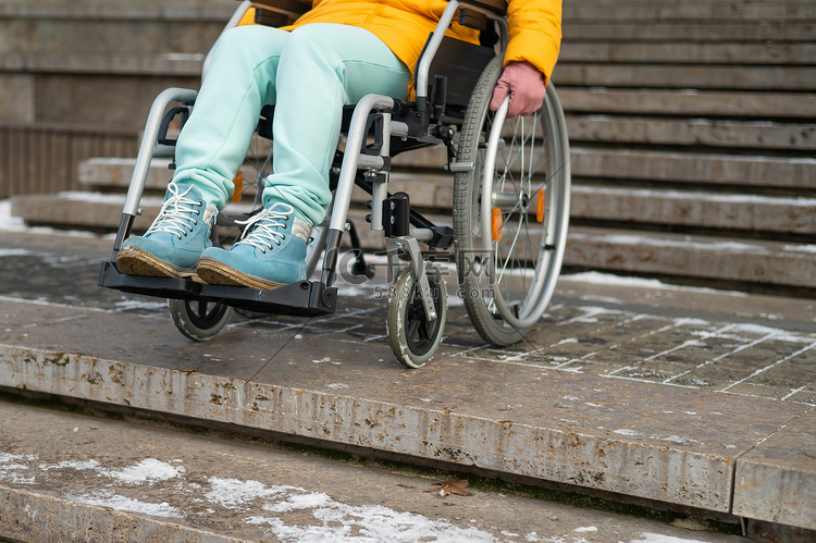 冬天在公园楼梯附近坐轮椅的女人