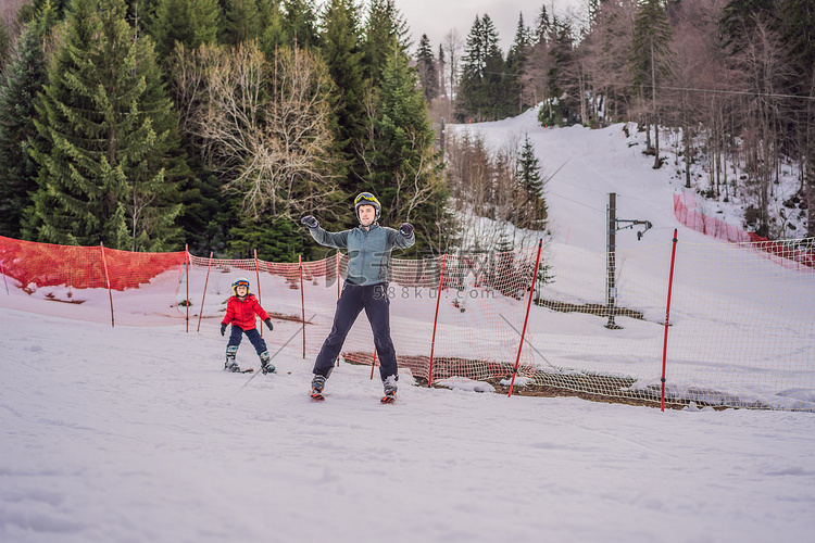 冬天，男孩在斜坡上学习滑雪、训