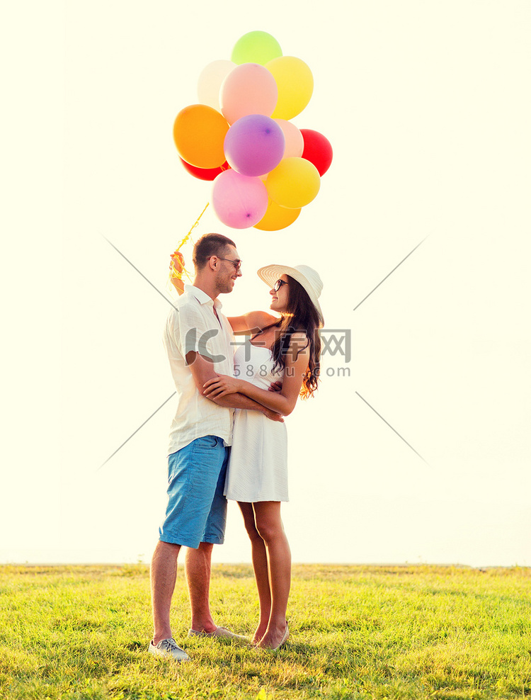 带着气球在户外微笑的情侣