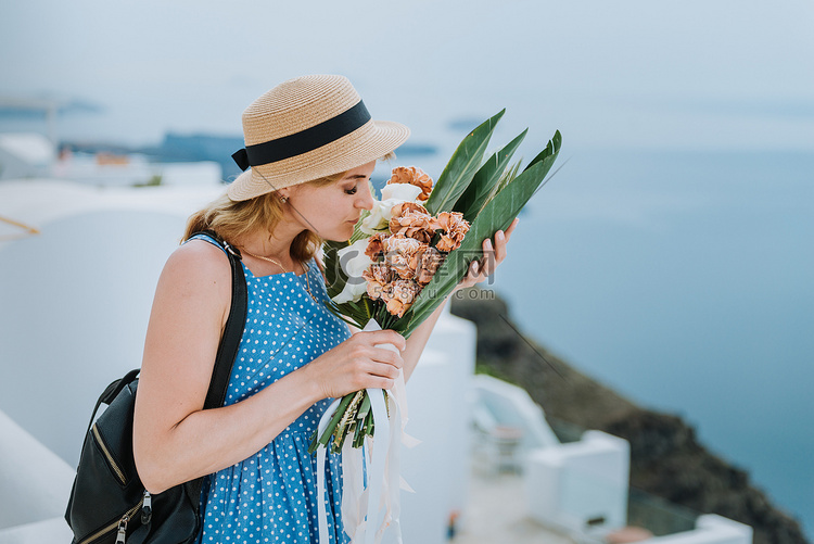 美丽的女孩带着花束沿着希腊欧洲