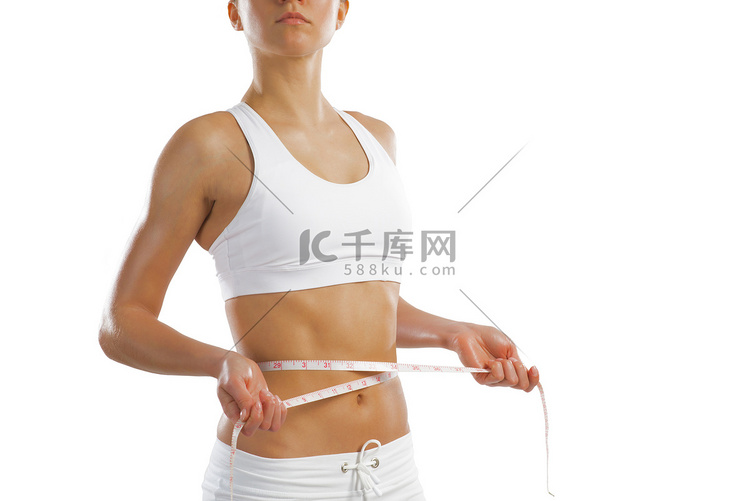 测量腰围的年轻运动女性