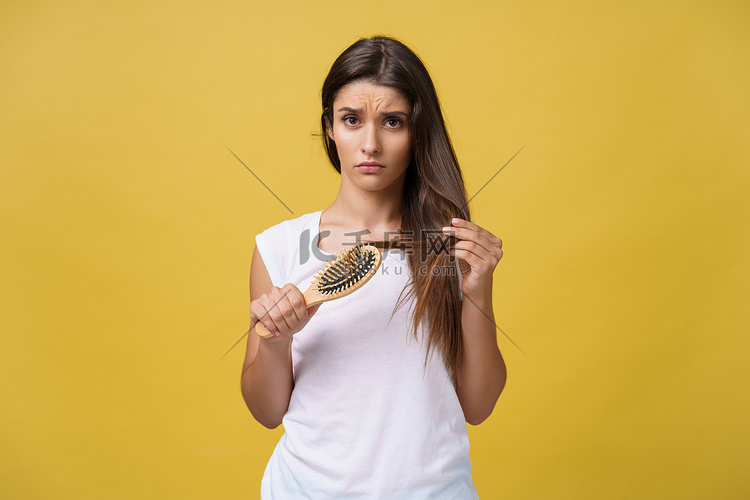 女人手握着长发，看着头发护理问