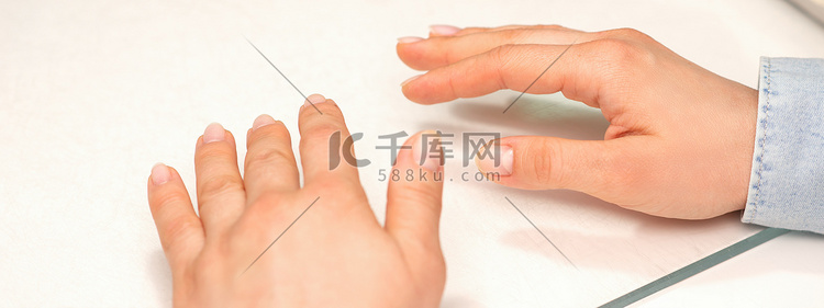 一位年轻女子的手，指甲整齐地放