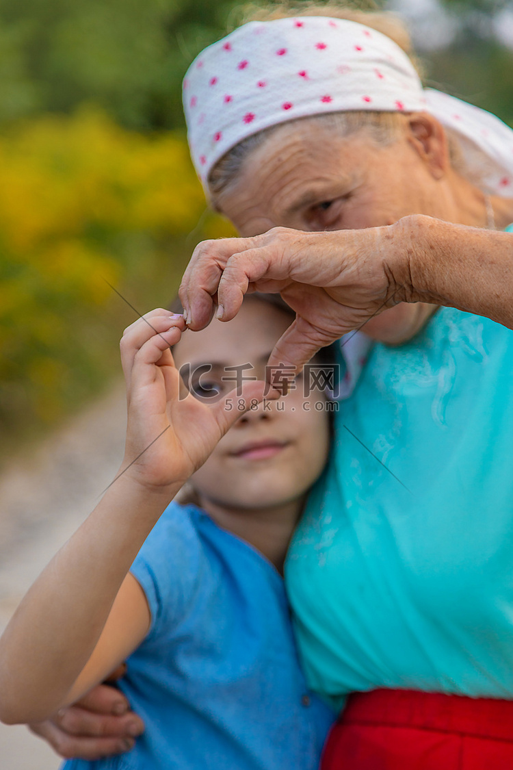 奶奶和孙女用手捏出一个心形。