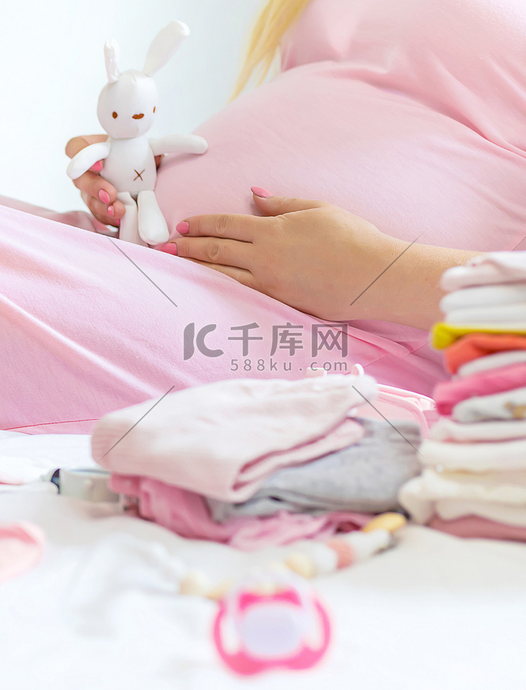 一名孕妇正在折叠婴儿用品。