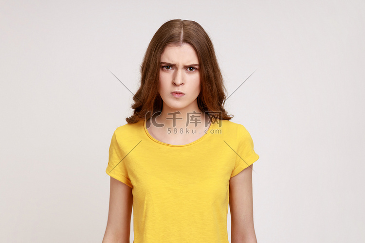 年轻美丽的非常愤怒的少女穿着黄
