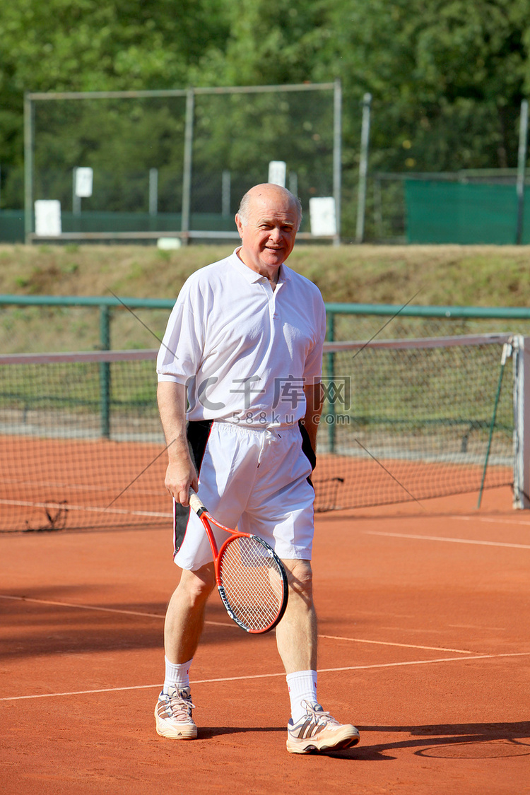 一位活跃的老年人正在打网球