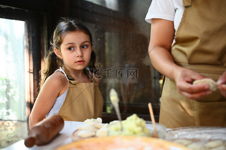 美丽的白人小女孩站在乡村厨房里