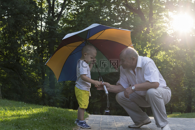 日落时分，孙子和祖父在明亮的雨