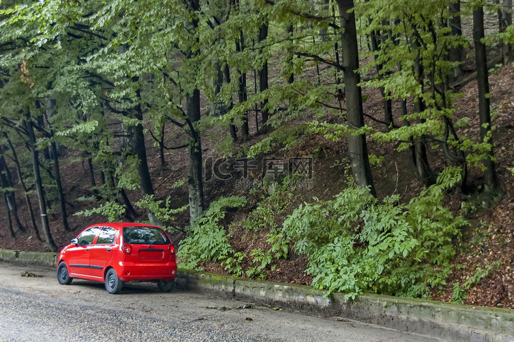 雨天巴尔干山风景如画的红色汽车