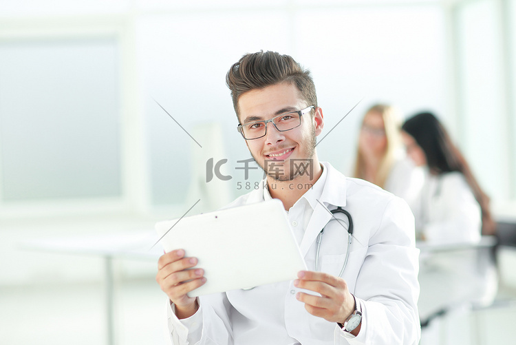微笑的医生看着数字平板电脑屏幕