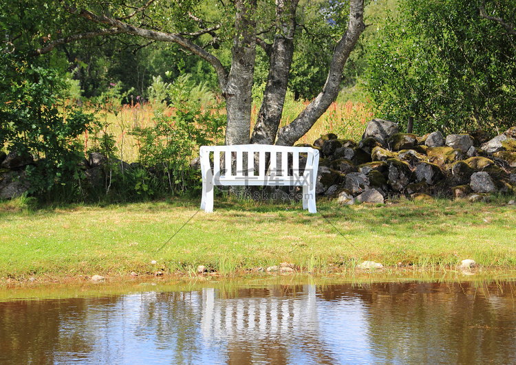 在湖的白色长凳有水倒影的