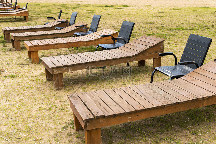 湖沙滩上的木制躺椅和椅子。