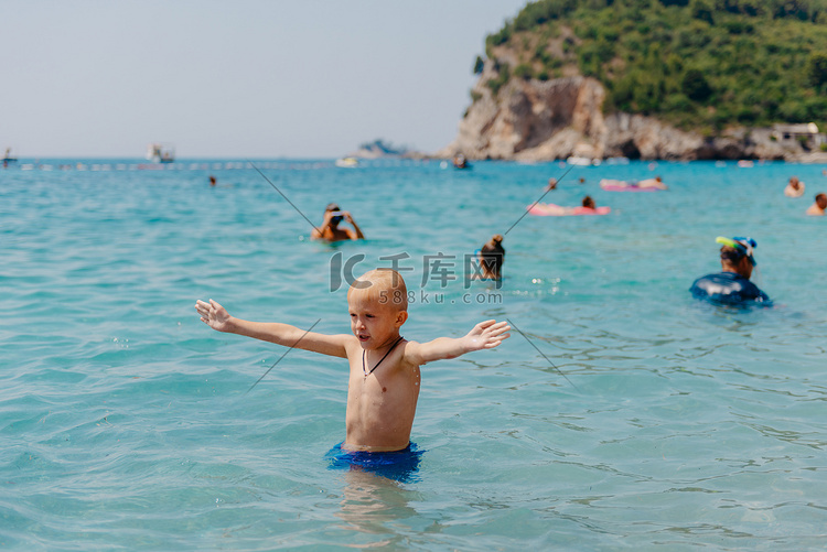 孩子在热带度假村的公海上学习游