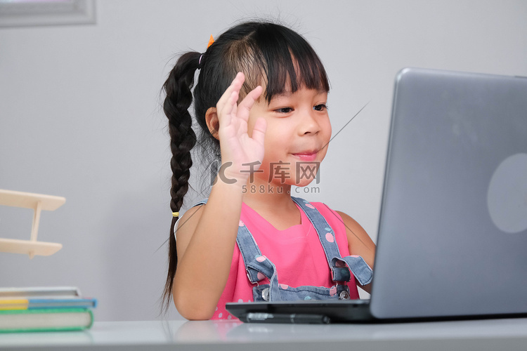 微笑的亚洲小女孩在网上学习，使