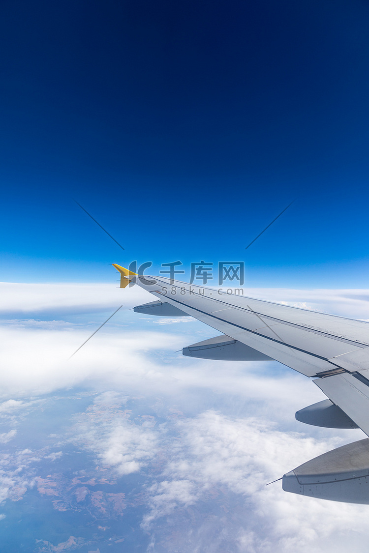 从乘客窗口可以看到蓝天下的飞机
