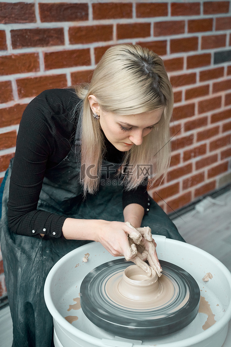 女人在轮子上制作陶瓷陶器，手特