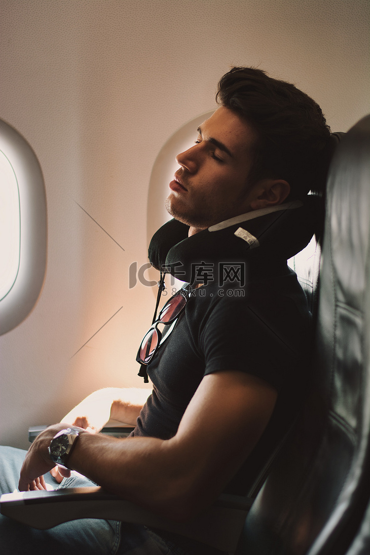 英俊的年轻人睡在飞机上