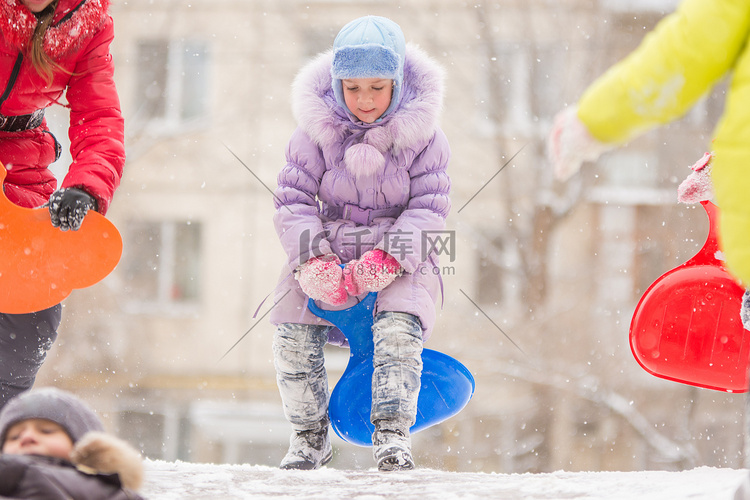 有趣的五岁女孩跑上冰山滚下