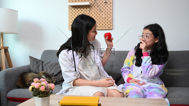 两个亚洲女孩在家里扮演医生和病