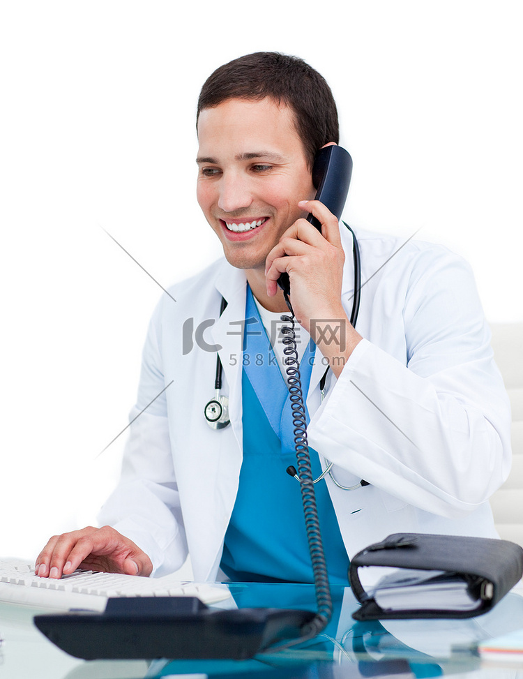 年轻男医生在电脑前打电话工作