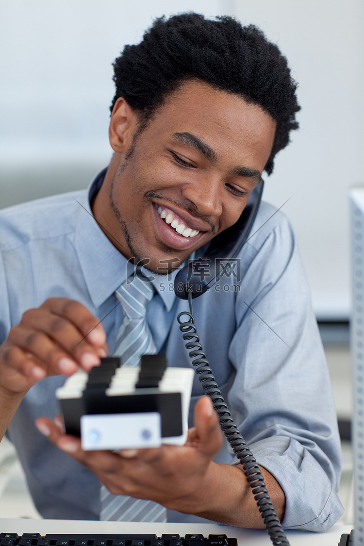 微笑的商人在电话里看着持卡人