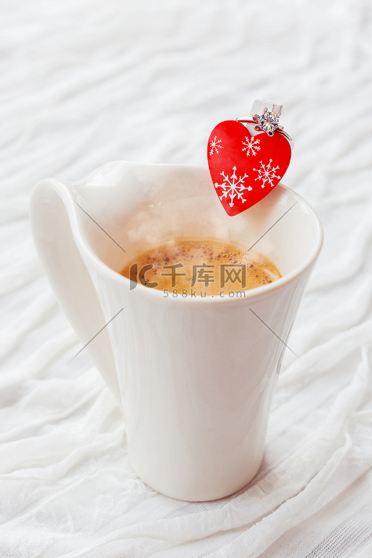 白杯热咖啡，装饰着心形和订婚钻