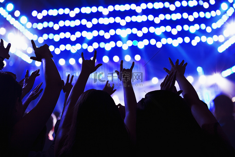 观看摇滚表演的观众，双手举在空