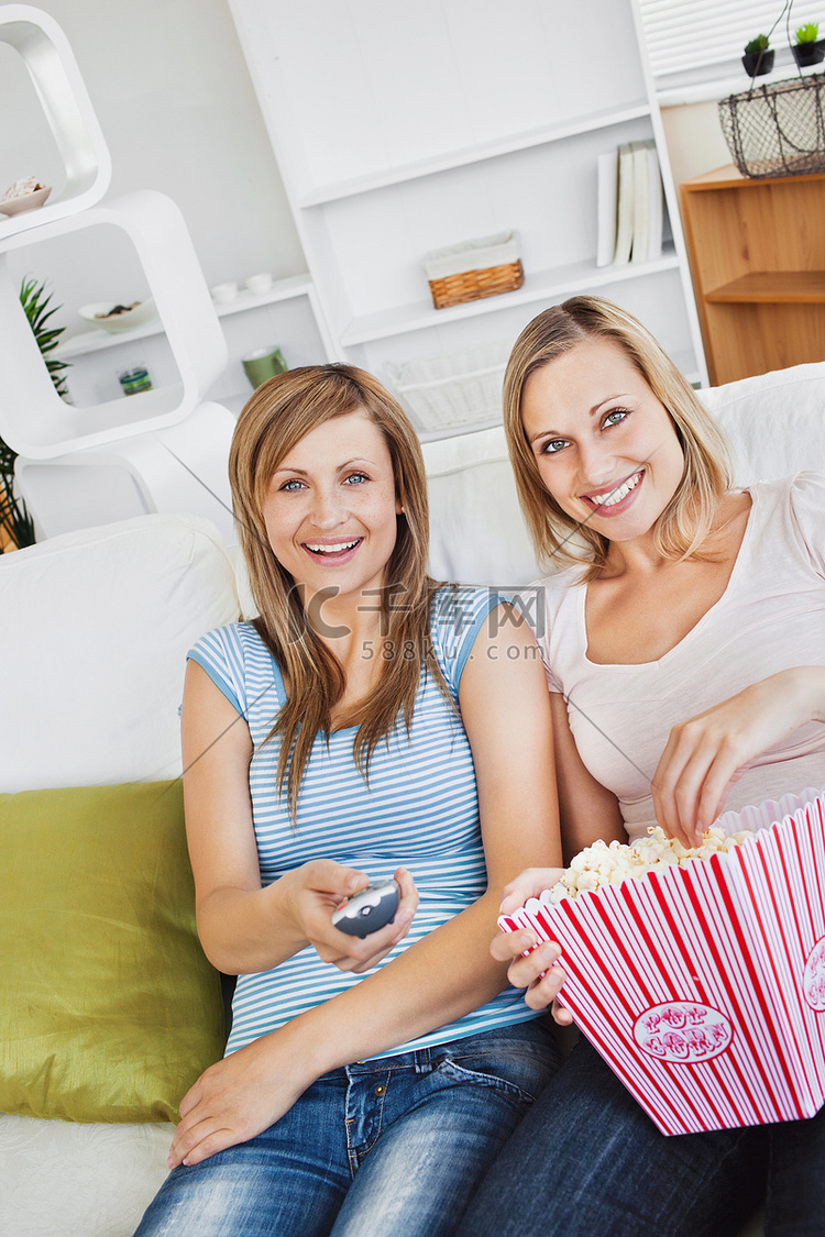 两个漂亮的女性朋友在沙发上看电
