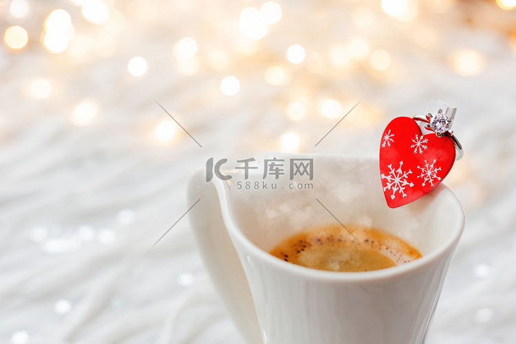 白杯热咖啡，装饰着心形和订婚钻