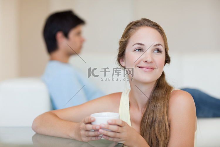 未婚夫坐在沙发上喝咖啡的女人