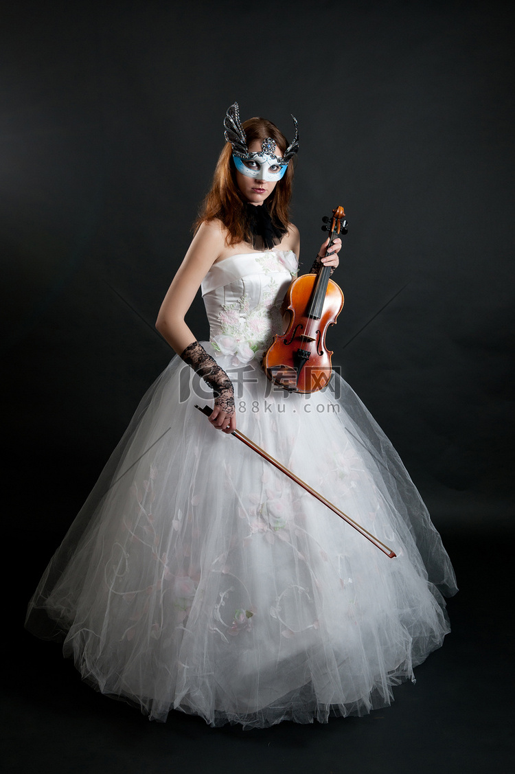 白色礼服和面具的女孩有小提琴的