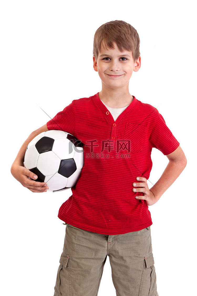 可爱的男孩拿着一个足球。