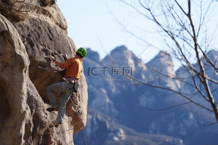青年男人在悬崖峭壁上攀岩