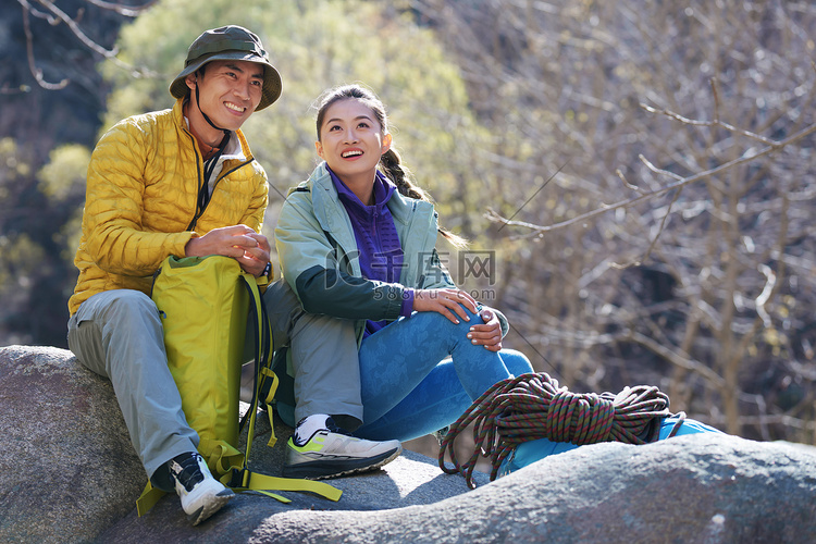 徒步旅行的青年伴侣坐在石头上休