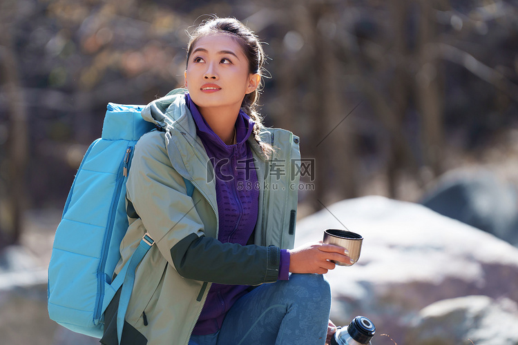 徒步旅行的青年女人坐着休息
