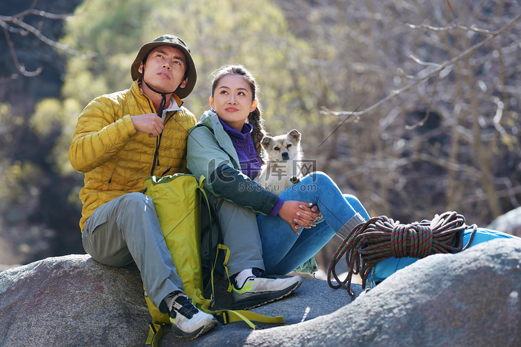 徒步旅行的青年伴侣坐在石头上休