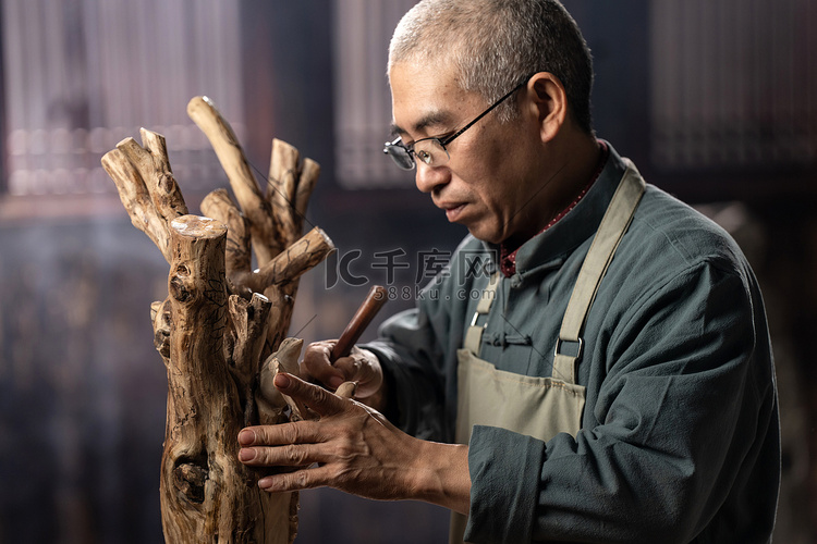 在树根上认真雕刻的工匠师