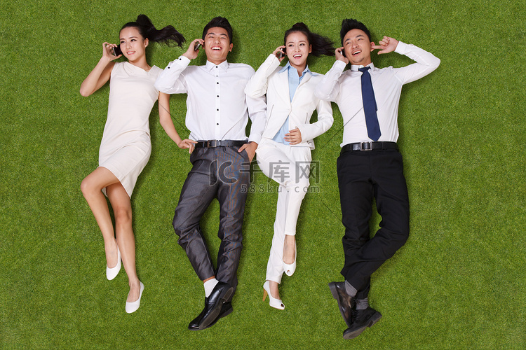 青年男女躺在草地上打电话