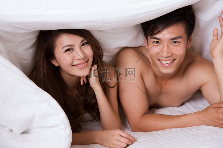 东方年轻夫妇趴在床上