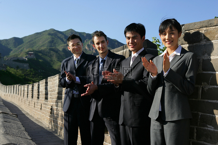 四位中外商务人士在长城上握手