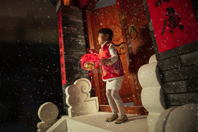 雪中小女孩手提红灯笼玩耍