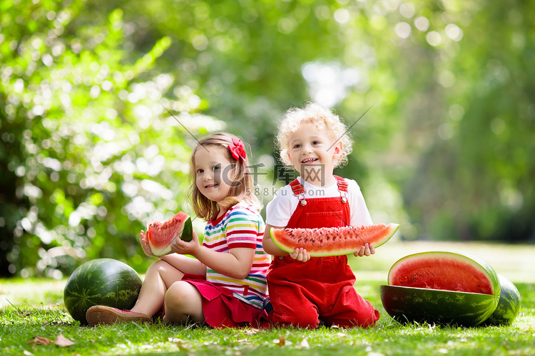 孩子在花园里吃西瓜。孩子们在户