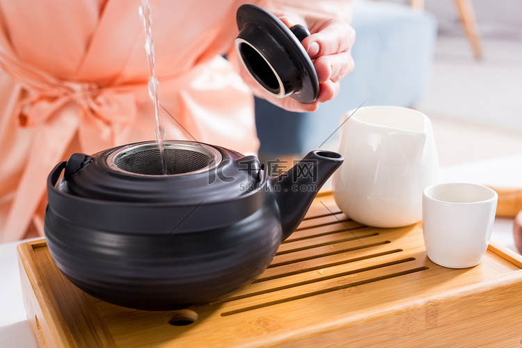女性在早上喝茶的时候在家里做茶