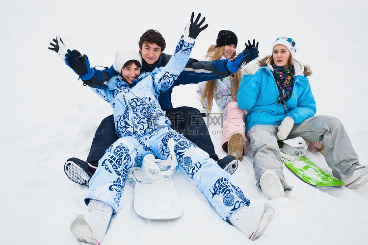 四个 snowborders 坐在雪上