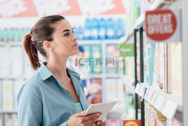 妇女在商店购物和使用数字触摸屏
