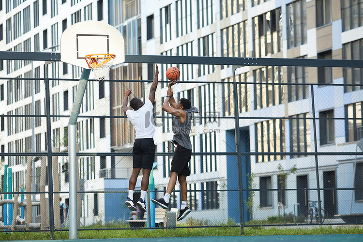 两个非裔美国人在户外球场上打篮
